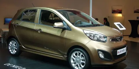 Kia Picanto color oro, in esposizione. Nessun difetto visibile, solo un'auto nuova.
