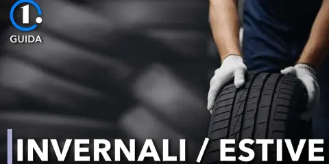Guida: cambio gomme invernali in estate. Mani guantate tengono un pneumatico.