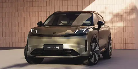 Lynk & Co 08, un SUV moderno con fari a LED distintivi, si presenta con un design audace su uno sfondo di mattoni.