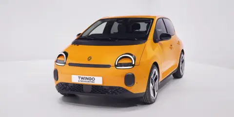 Renault elettrica piccola color arancio brillante, con fari rotondi e scritta "Twingo E-Tech Electric" sul frontale.