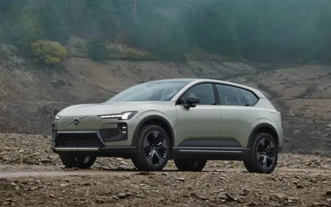 Volvo EX90, un SUV elettrico elegante, si avventura su un terreno roccioso e fangoso, pronto per l'esplorazione.