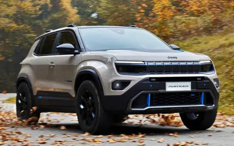 Jeep Avenger in beige, su strada autunnale. Nonostante le jeep avenger recensioni negative, il design è accattivante.
