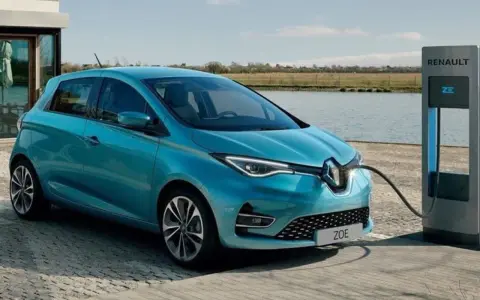 Renault Zoe, una delle auto elettriche più vendute, in carica vicino a un lago.