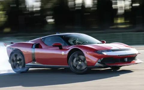 Ferrari 849 Testarossa sfreccia in pista, sollevando fumo dagli pneumatici. Un'icona di velocità e design.