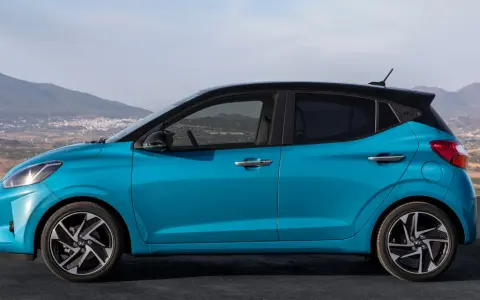 Hyundai i10 blu con tetto nero, vista laterale. Le dimensioni compatte la rendono perfetta per la città.