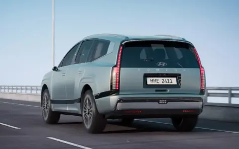 La nuova Ioniq 9, un SUV elettrico dal design futuristico, sfreccia su un'autostrada sotto un cielo azzurro.
