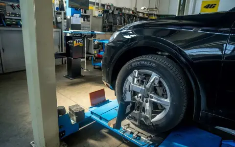 Auto in officina per controllo assetto ruote. Pneumatico Michelin, tra le migliori marche di pneumatici, montato su cerchio in lega.