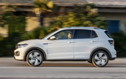 Bianca T-Cross sfreccia su strada, con la sua conducente che gode del viaggio. Un'auto compatta ma spaziosa, perfetta per ogni avventura.