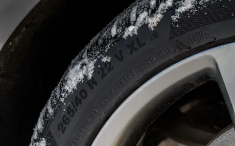 Pneumatici M+S con neve sul battistrada, pronti per affrontare l'inverno.