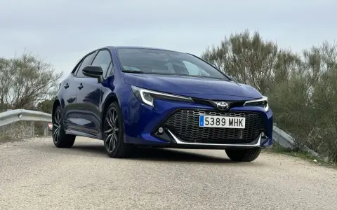 Toyota Corolla blu parcheggiata su strada sterrata, con vegetazione sullo sfondo. Un'auto che offre diverse motorizzazioni.