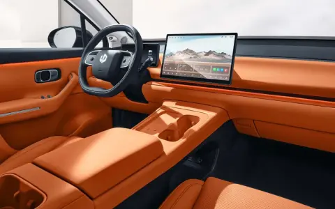 Interni eleganti e moderni della Leapmotor C10, con sedili in pelle arancione, ampio display centrale e volante sportivo.