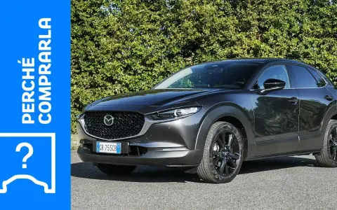Mazda CX-30 grigia parcheggiata, con testo "Perché comprarla" e un punto interrogativo. Valutazione dei **problemi** della Mazda CX-30.