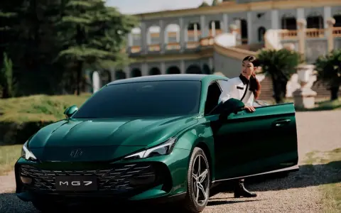 Elegante donna esce dalla MG 7 verde smeraldo, con un palazzo storico sullo sfondo.