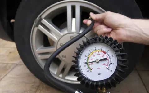 Controllo della pressione delle gomme auto con manometro. La lancetta indica circa 2 bar.