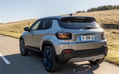 Jeep Avenger elettrica in corsa su strada panoramica, con cerchi blu e un'ottima autonomia per esplorare.