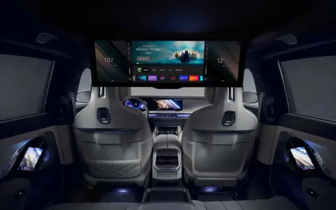 Interni lussuosi della BMW i7 con un grande schermo per l'intrattenimento e schermi sui pannelli delle porte.