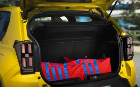 Bagagli rossi con strisce blu nel bagagliaio di una Fiat Panda, dimensioni generose per ogni avventura.