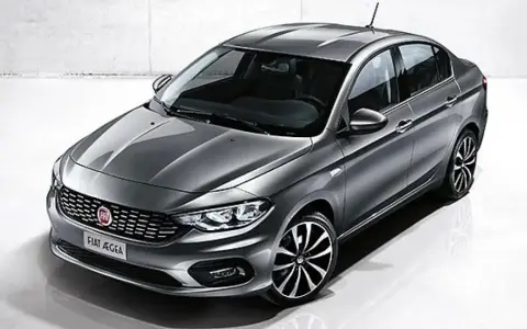 La Fiat Egea grigia, un'elegante berlina, si presenta in uno studio con un design moderno e cerchi sportivi.