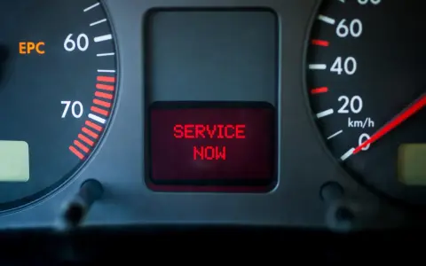 Car dashboard with EPC light on and "SERVICE NOW" message displayed in red.