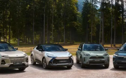 Quattro modelli Toyota, RAV4, C-HR, Yaris Cross e Corolla Cross, in un paesaggio boscoso.