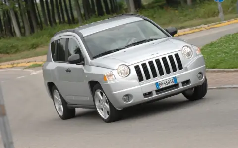 Jeep Compass in argento su strada sterrata, forse con qualche problema di trazione.