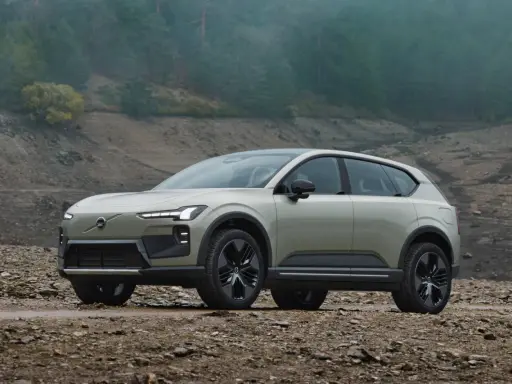 Volvo EX90, un SUV elettrico elegante, si avventura su un terreno roccioso e fangoso, pronto per l'esplorazione.