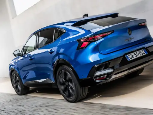 La nuova Renault Rafale blu elettrico sfreccia con stile, mostrando il suo design audace e moderno.