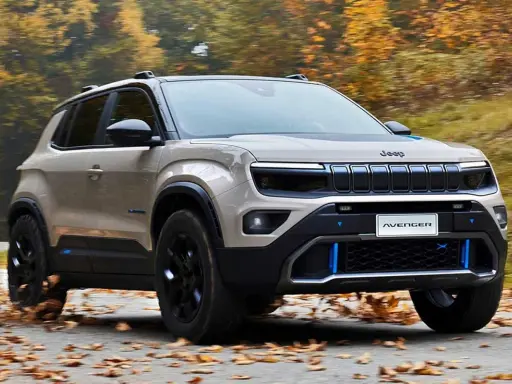 Jeep Avenger in beige, su strada autunnale. Nonostante le jeep avenger recensioni negative, il design è accattivante.
