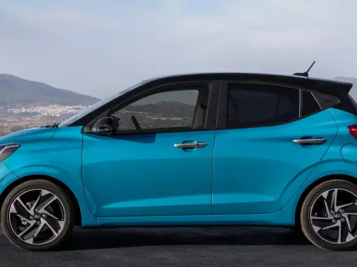 Hyundai i10 blu con tetto nero, vista laterale. Le dimensioni compatte la rendono perfetta per la città.