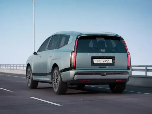 La nuova Ioniq 9, un SUV elettrico dal design futuristico, sfreccia su un'autostrada sotto un cielo azzurro.