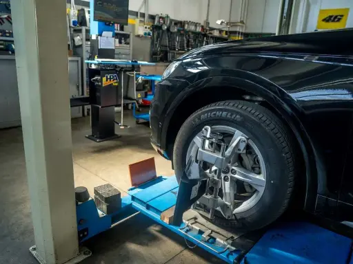 Auto in officina per controllo assetto ruote. Pneumatico Michelin, tra le migliori marche di pneumatici, montato su cerchio in lega.