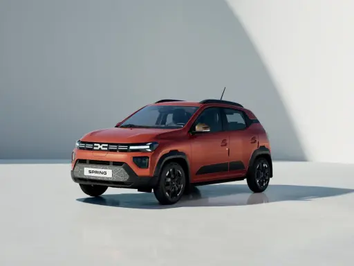Dacia Spring, un'auto elettrica arancione, pronta per un viaggio in autostrada con la sua autonomia.