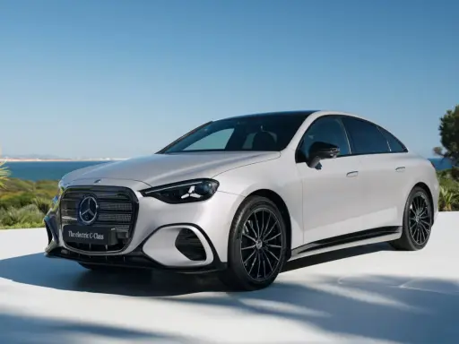 La Mercedes Classe C 2026, un'elegante berlina elettrica, si presenta con un design moderno e sportivo, con cerchi neri e uno sfondo marino.