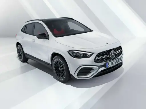 La nuova GLA 2026, un SUV bianco con tetto nero e interni rossi, si presenta in uno studio minimalista.