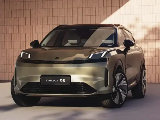 Lynk & Co 08, un SUV moderno con fari a LED distintivi, si presenta con un design audace su uno sfondo di mattoni.