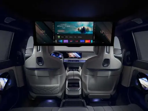Interni lussuosi della BMW i7 con un grande schermo per l'intrattenimento e schermi sui pannelli delle porte.