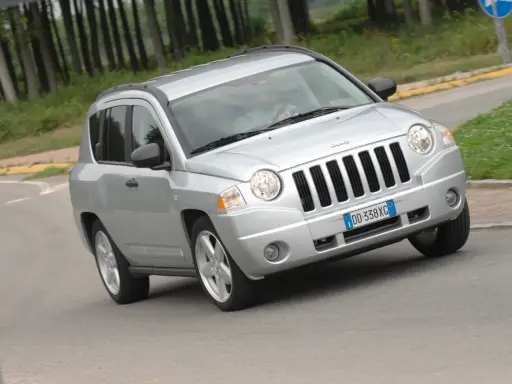 Jeep Compass in argento su strada sterrata, forse con qualche problema di trazione.