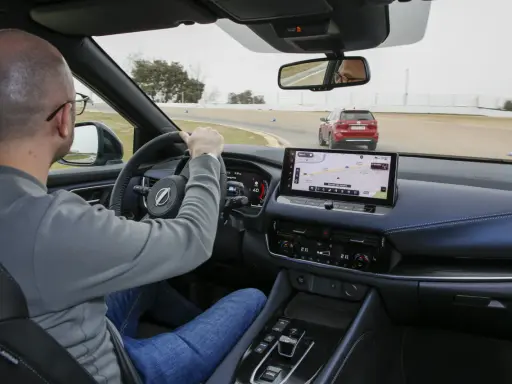Uomo al volante su una pista, con un'altra auto rossa davanti. Il navigatore mostra il "Circuito del Jarama", ideale per chi vuole aumentare cavalli auto.