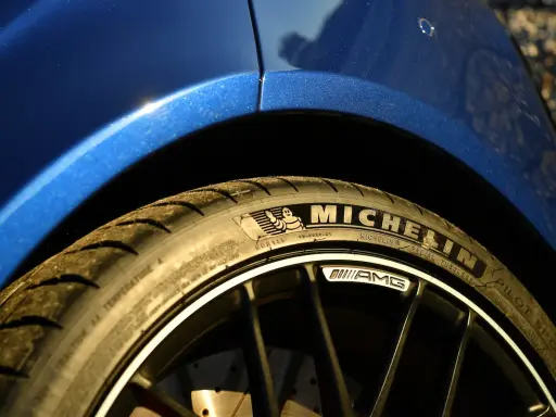 Gomme Michelin Pilot Sport su cerchio AMG di un'auto blu scintillante.