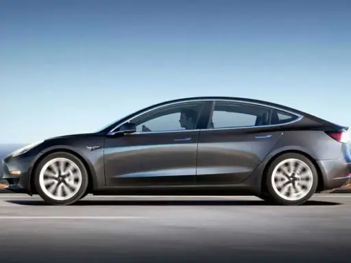 Tesla grigia in movimento su strada, con un conducente al volante. Quanti km fa una Tesla? Dipende dal modello e dalla batteria.