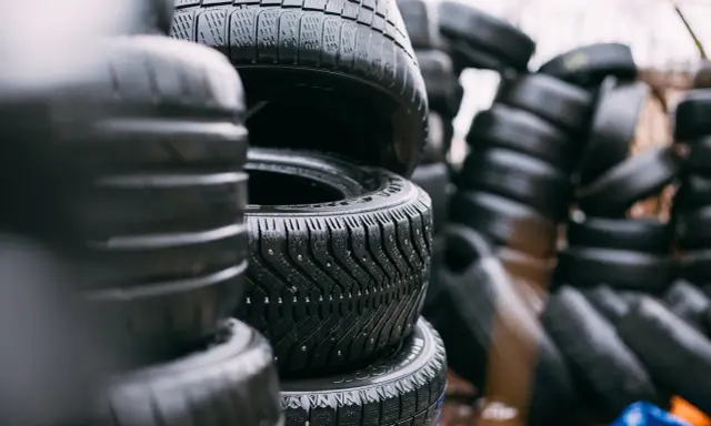 Pile di gomme invernali con chiodi, pronte per affrontare la neve. La sigla gomme invernali è ben visibile sul battistrada.