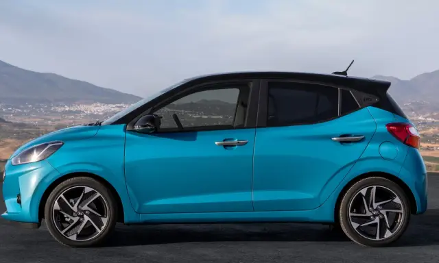 Hyundai i10 blu con tetto nero, vista laterale. Le dimensioni compatte la rendono perfetta per la città.