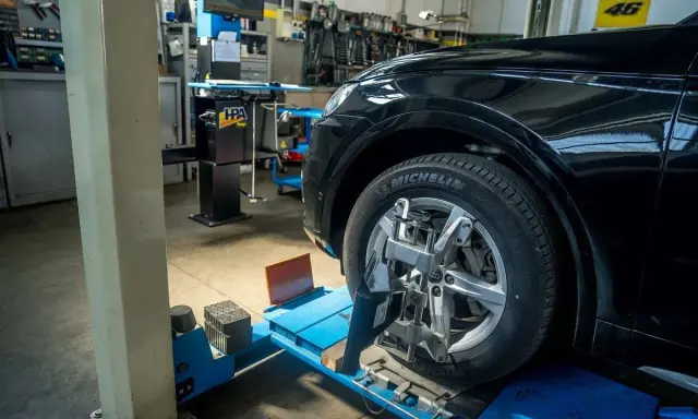 Auto in officina per controllo assetto ruote. Pneumatico Michelin, tra le migliori marche di pneumatici, montato su cerchio in lega.