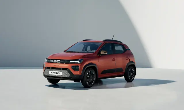 Dacia Spring, un'auto elettrica arancione, pronta per un viaggio in autostrada con la sua autonomia.
