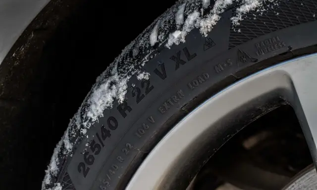 Pneumatici M+S con neve sul battistrada, pronti per affrontare l'inverno.