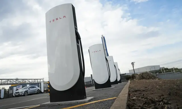 Stazione di ricarica Tesla Supercharger, con una Tesla in carica. Il costo del servizio è un fattore importante per i proprietari.