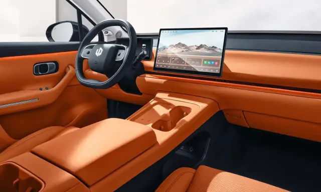 Interni eleganti e moderni della Leapmotor C10, con sedili in pelle arancione, ampio display centrale e volante sportivo.