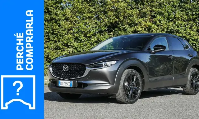 Mazda CX-30 grigia parcheggiata, con testo "Perché comprarla" e un punto interrogativo. Valutazione dei **problemi** della Mazda CX-30.