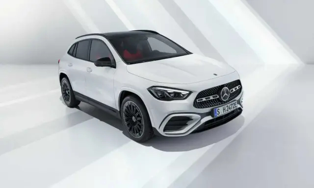 La nuova GLA 2026, un SUV bianco con tetto nero e interni rossi, si presenta in uno studio minimalista.