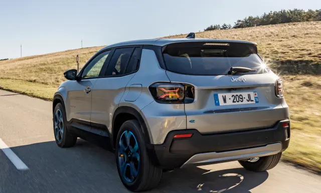 Jeep Avenger elettrica in corsa su strada panoramica, con cerchi blu e un'ottima autonomia per esplorare.